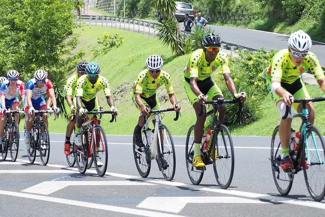 Peloton de cyclistes sur une route vallonnée de Martinique