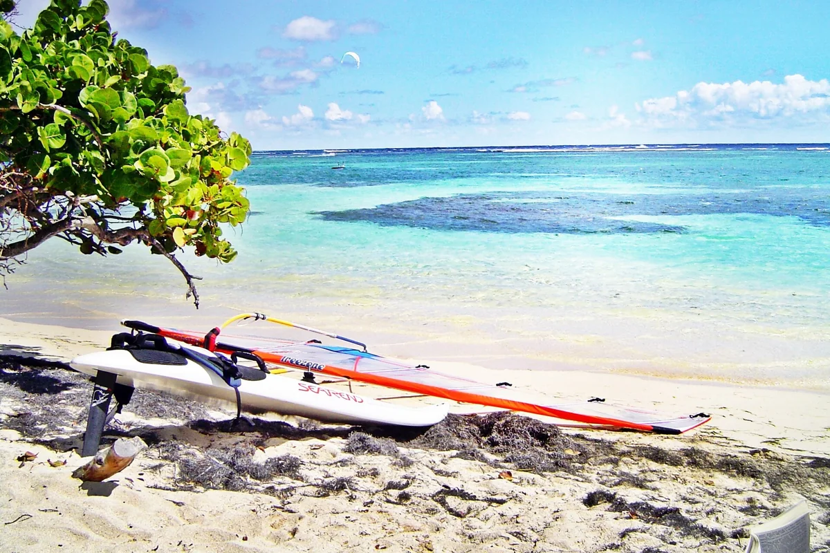 Matériel de planche à voile posé sur une plage de Sainte-Anne en Martinique